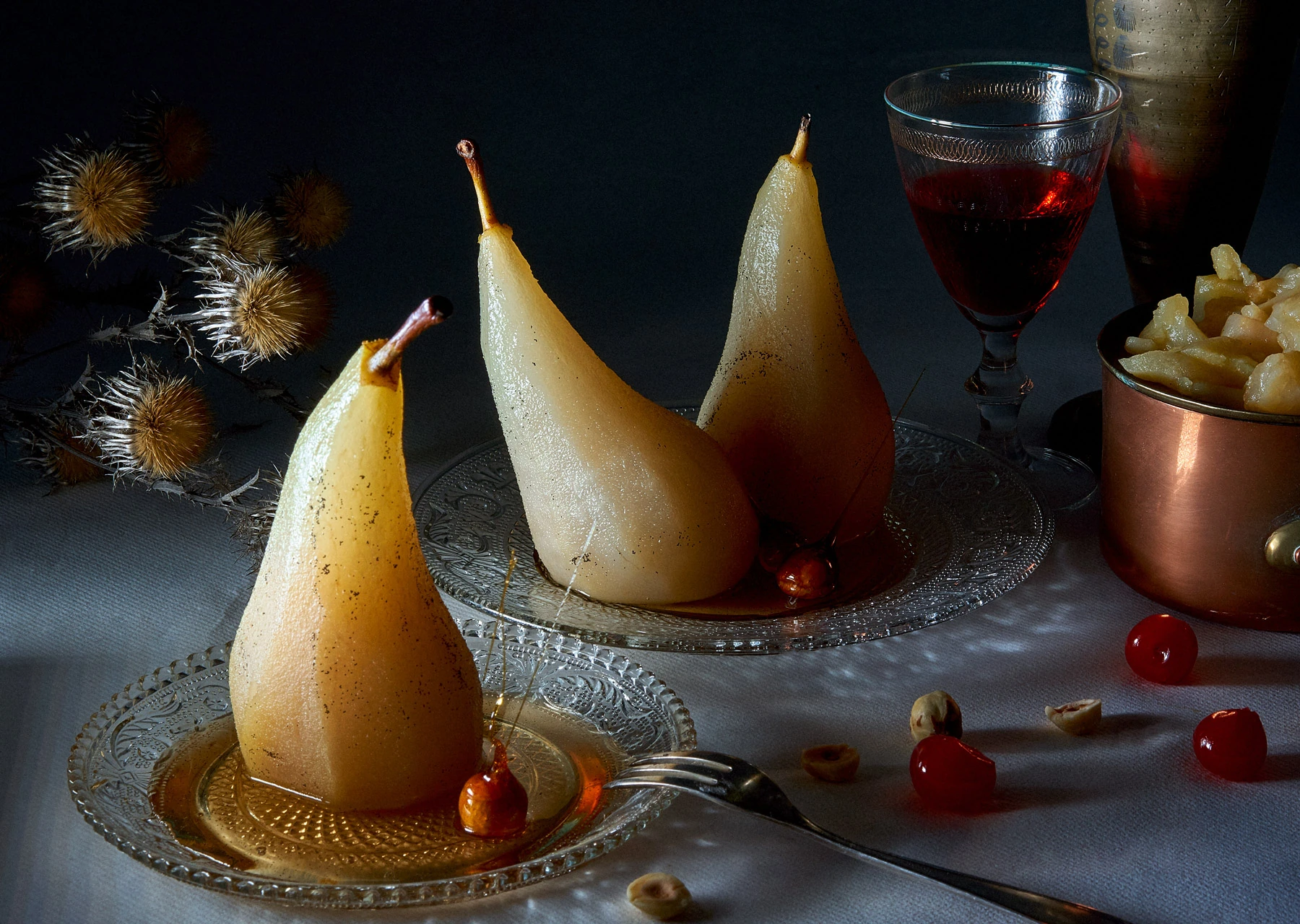 Poires pochées présentées en nature morte sombre