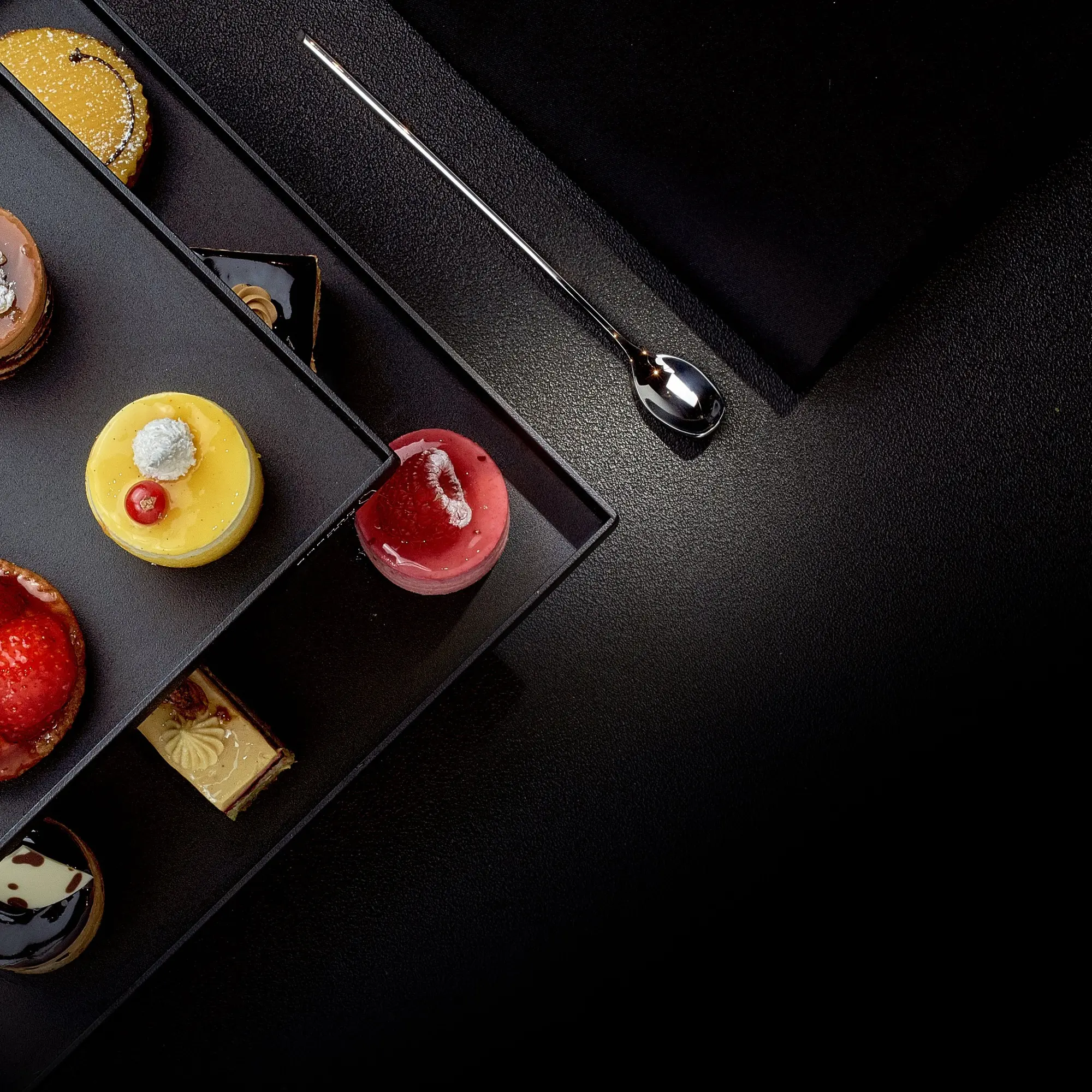 Sélection de mignardises colorées photographiées sur fond noir