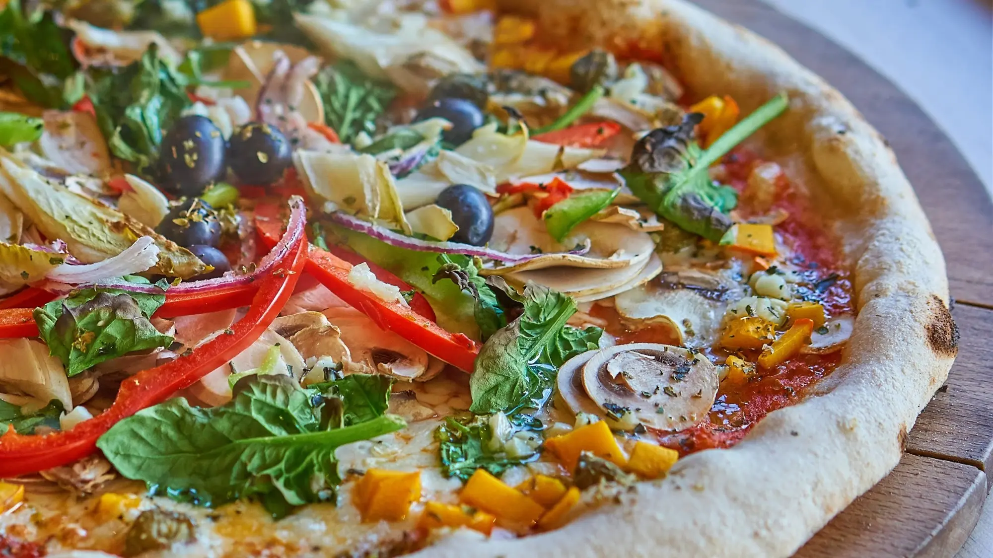 Pizza artisanale garnie de légumes colorés
